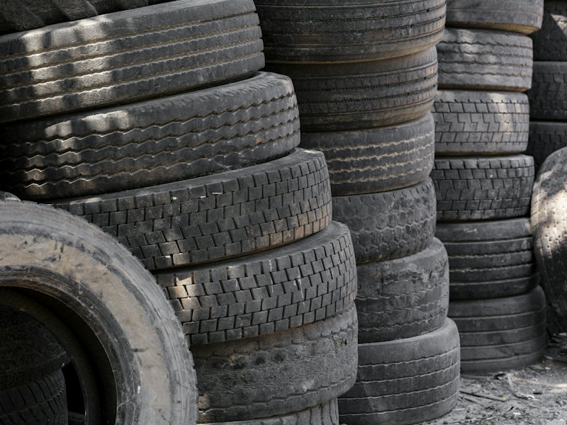 Old vehicle parts and tires stacked for recycling