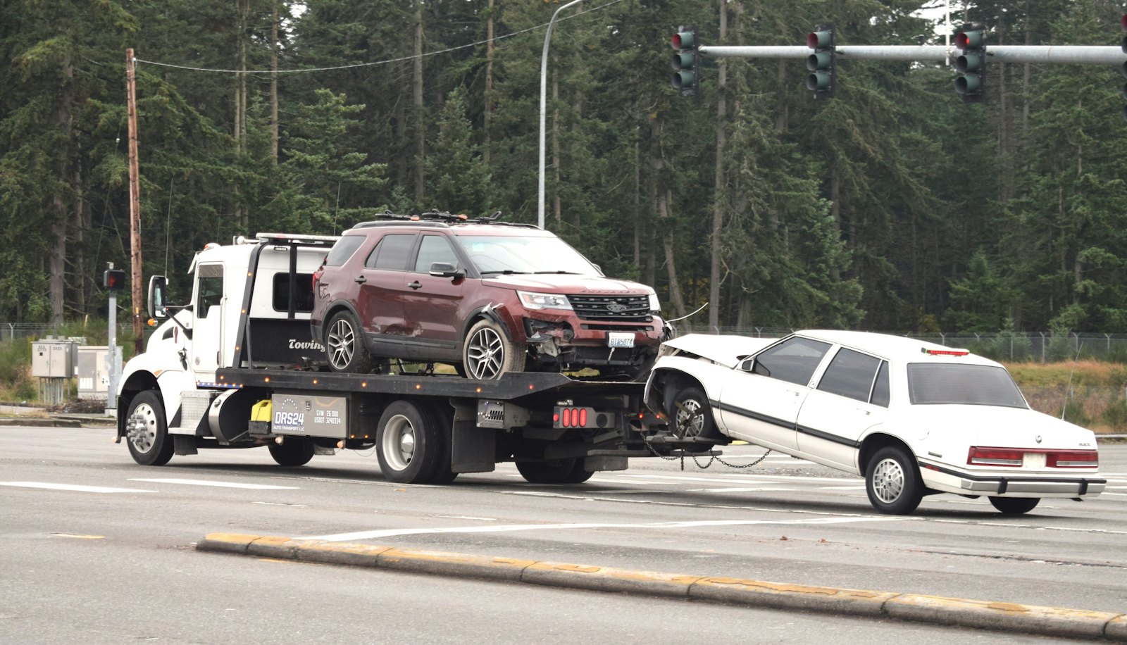 Tow truck hauling a car down a highway
