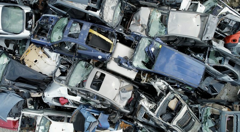 Crushed cars stacked for recycling in a scrap yard